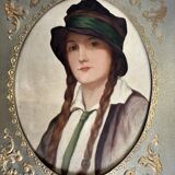 Old portrait of a young woman with braids and a hat, circa 1930