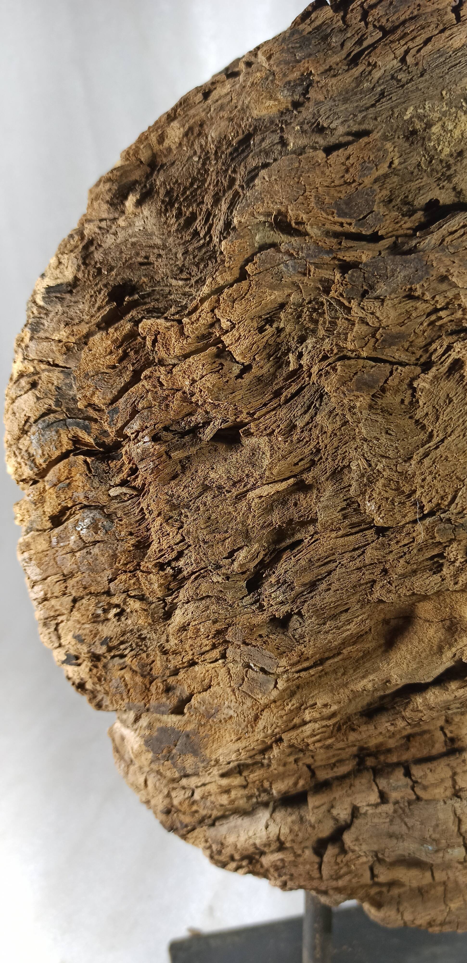 Old wooden pulley wheel on foot