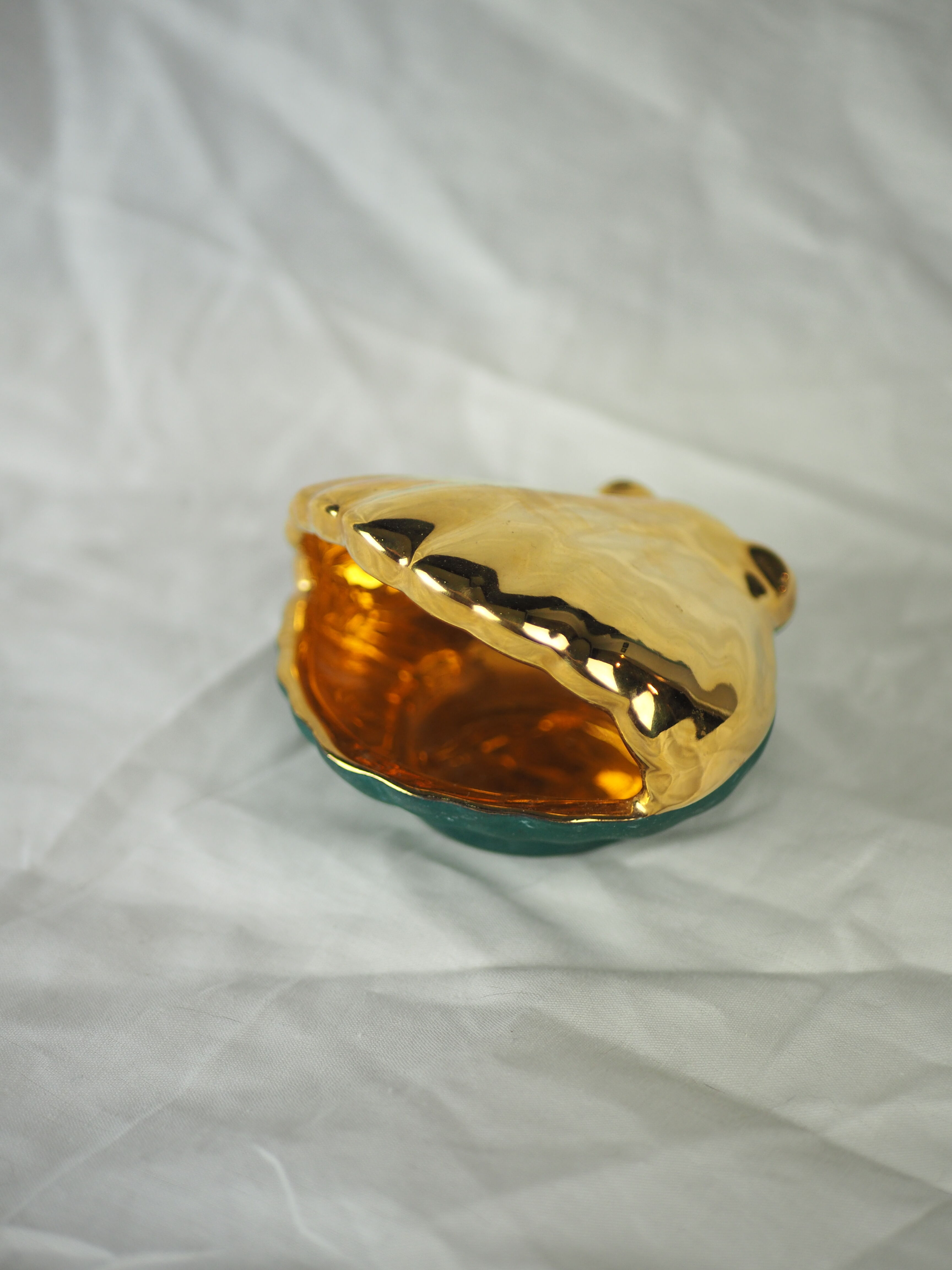 Porcelain pocket tray in the shape of a golden scallop shell with duck green background from the 50s/60s