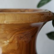 Artisanal turned olive wood vase with varnish.