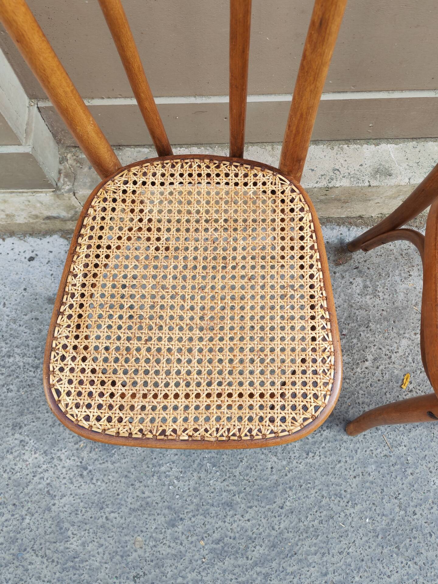 Pair of vintage bistro chairs in curved wood and caning.
