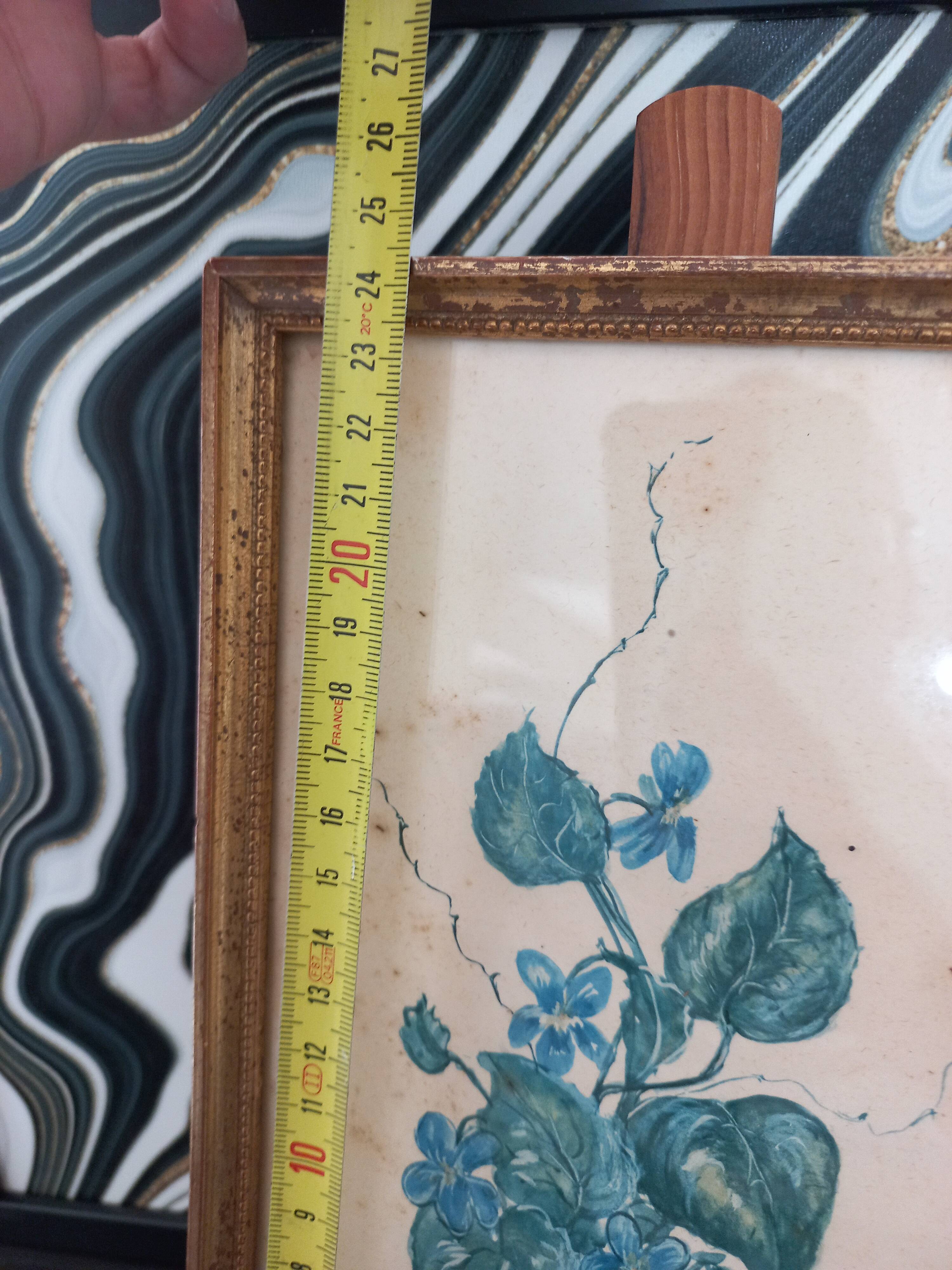 Decorative table with vintage blue flowers in a golden frame.