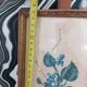 Decorative table with vintage blue flowers in a golden frame.