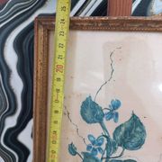 Decorative table with vintage blue flowers in a golden frame.