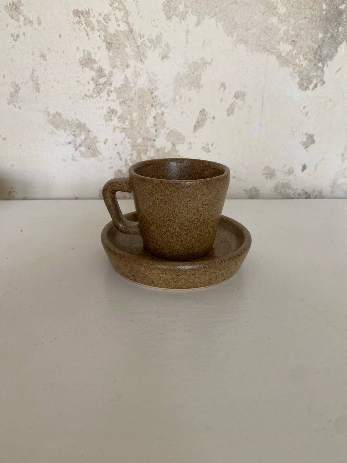 Set of stoneware coffee cups with saucers