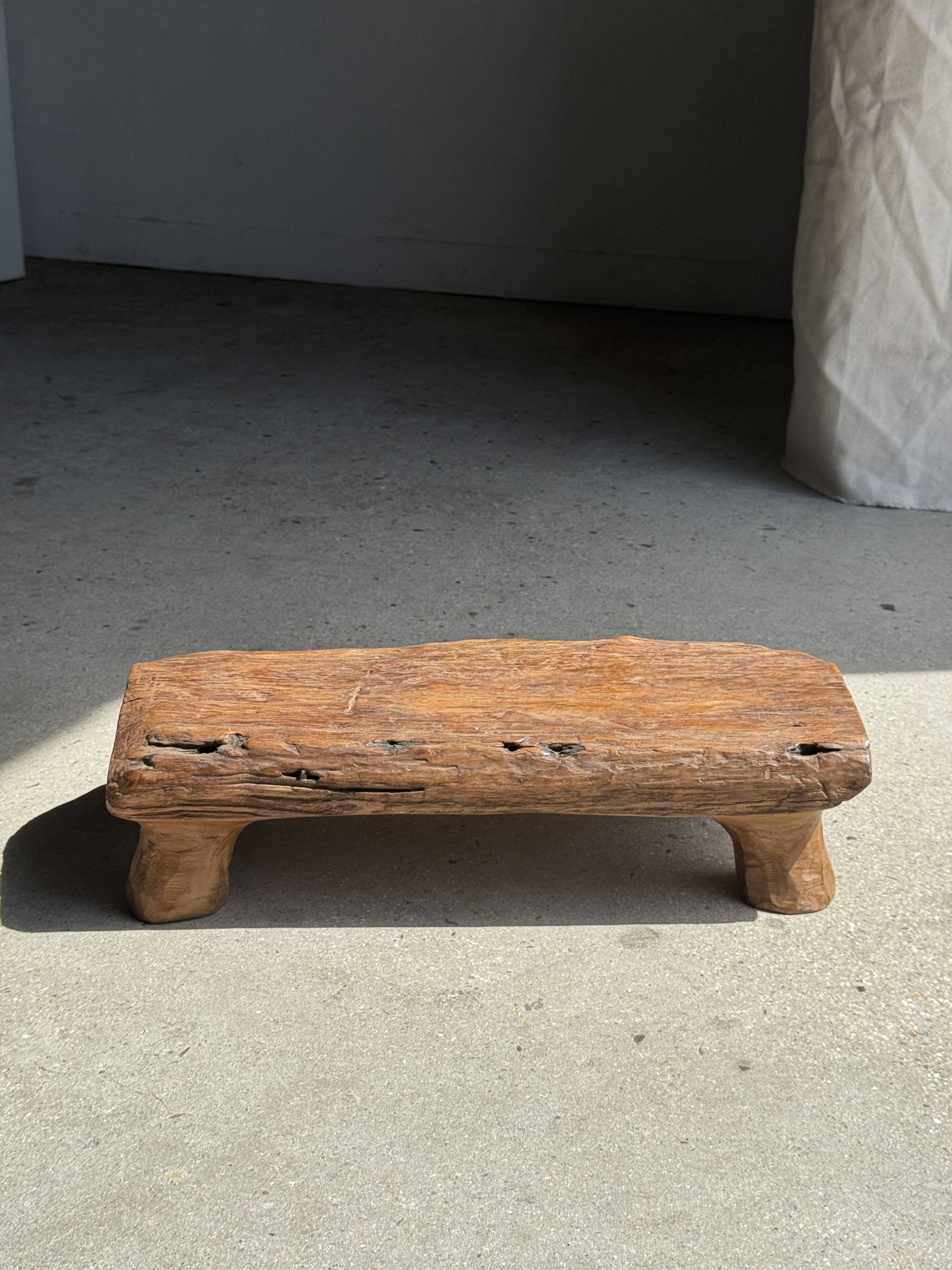 Small stool, footrest in blond teak, organic monoxyle with cut corners.
