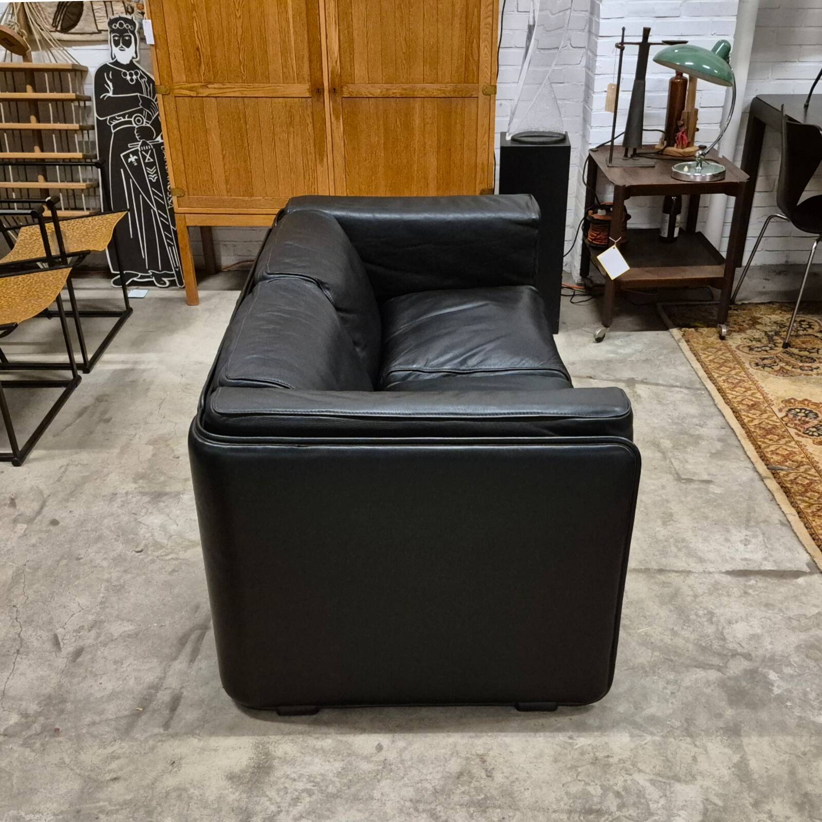 Two-seater sofa in black leather, designed by Tito Agnoli for Poltrona Frau, Italy, 1980s