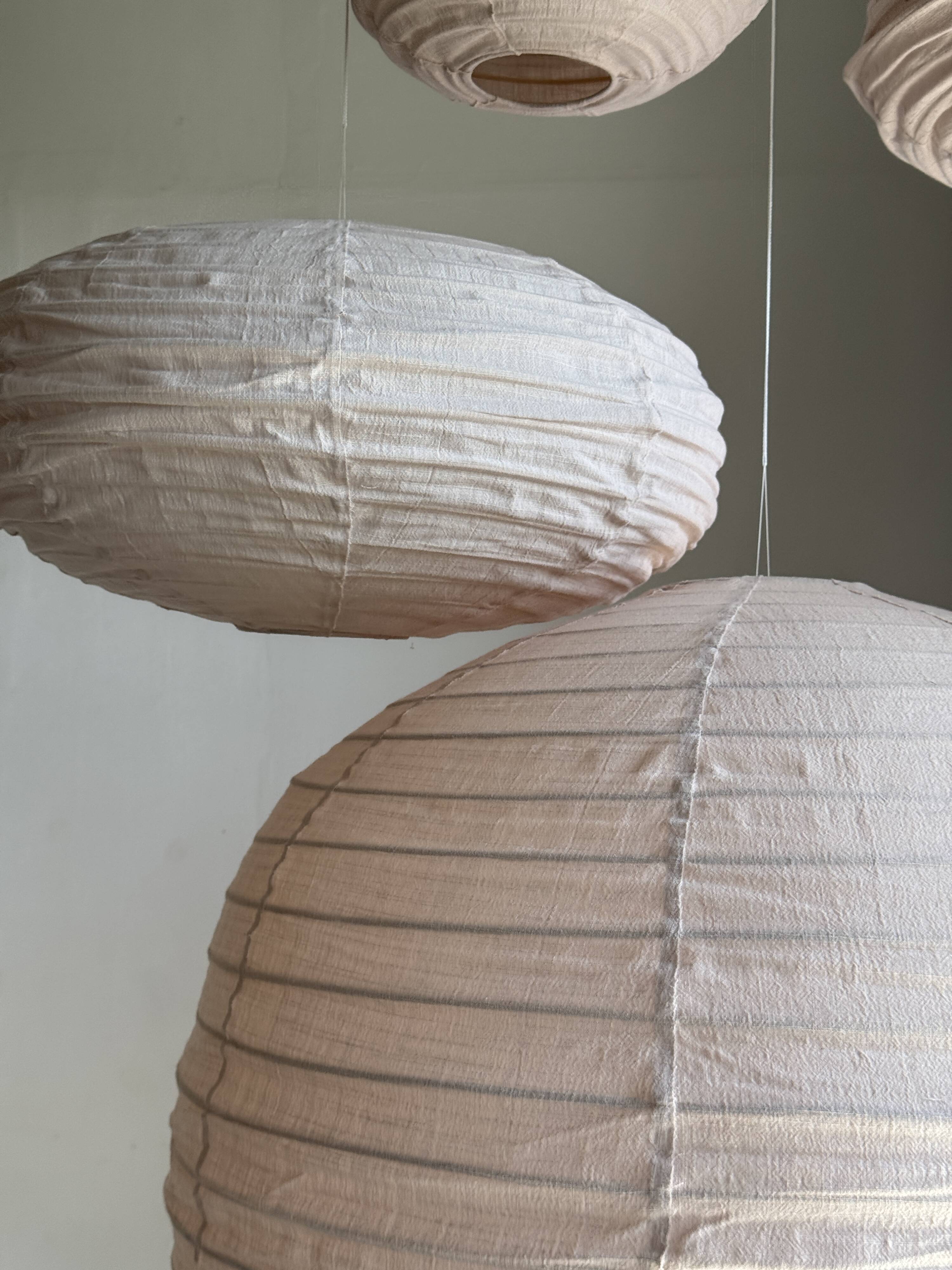 Average suspension in natural rattan and linen, Japanese-style, flattened oval in pink.