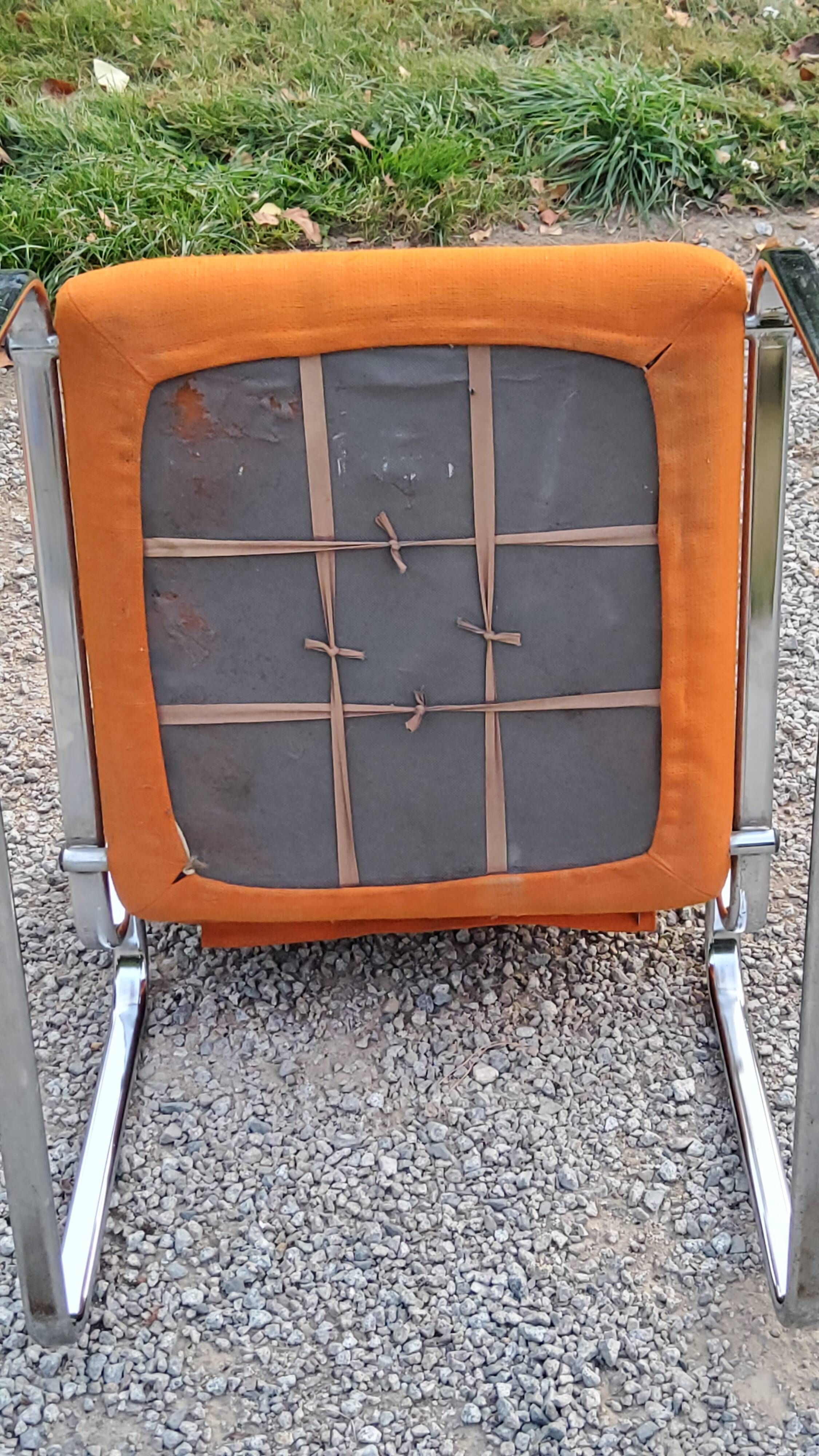 Pair of designer armchairs in orange fabrics and chrome tubes from the 70s