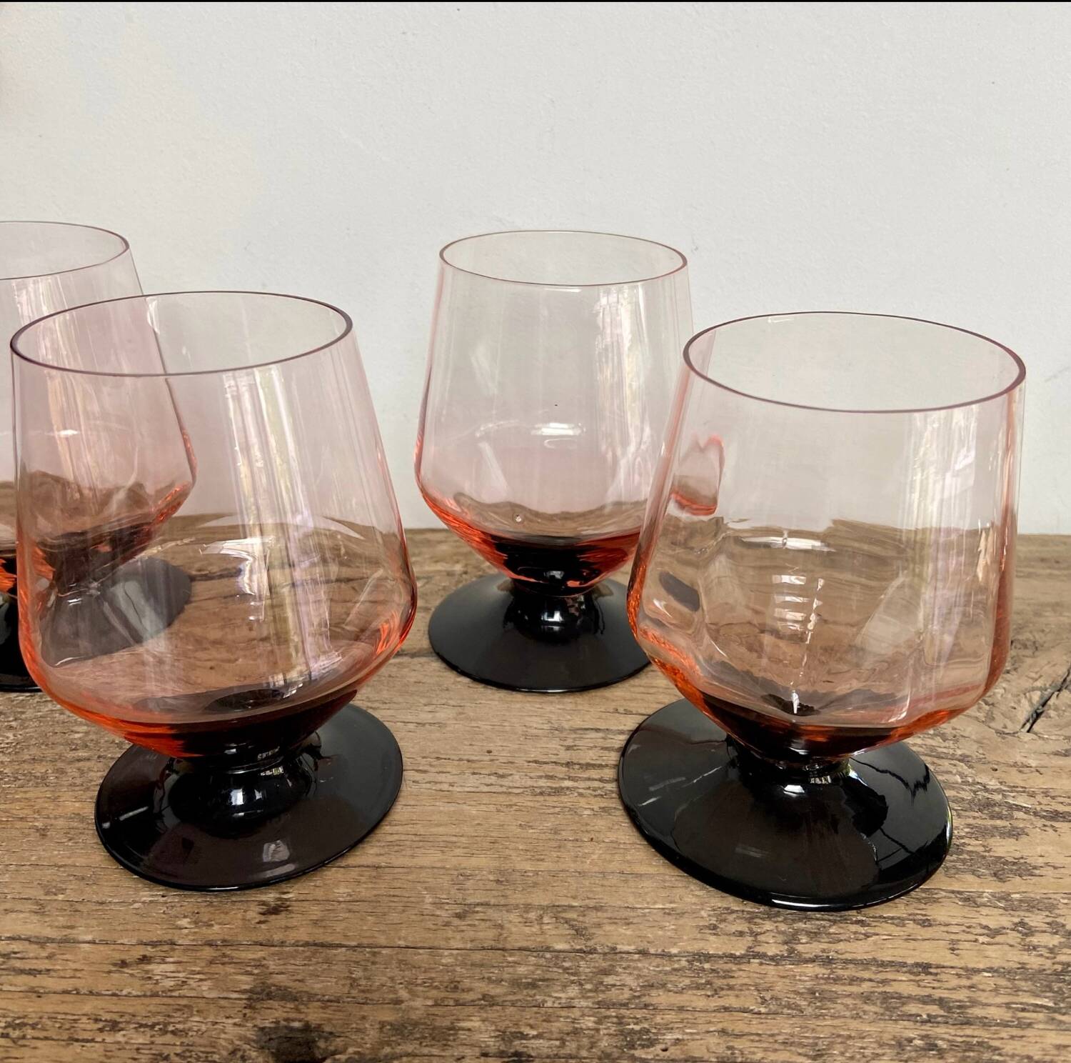4 pink glasses with black stems