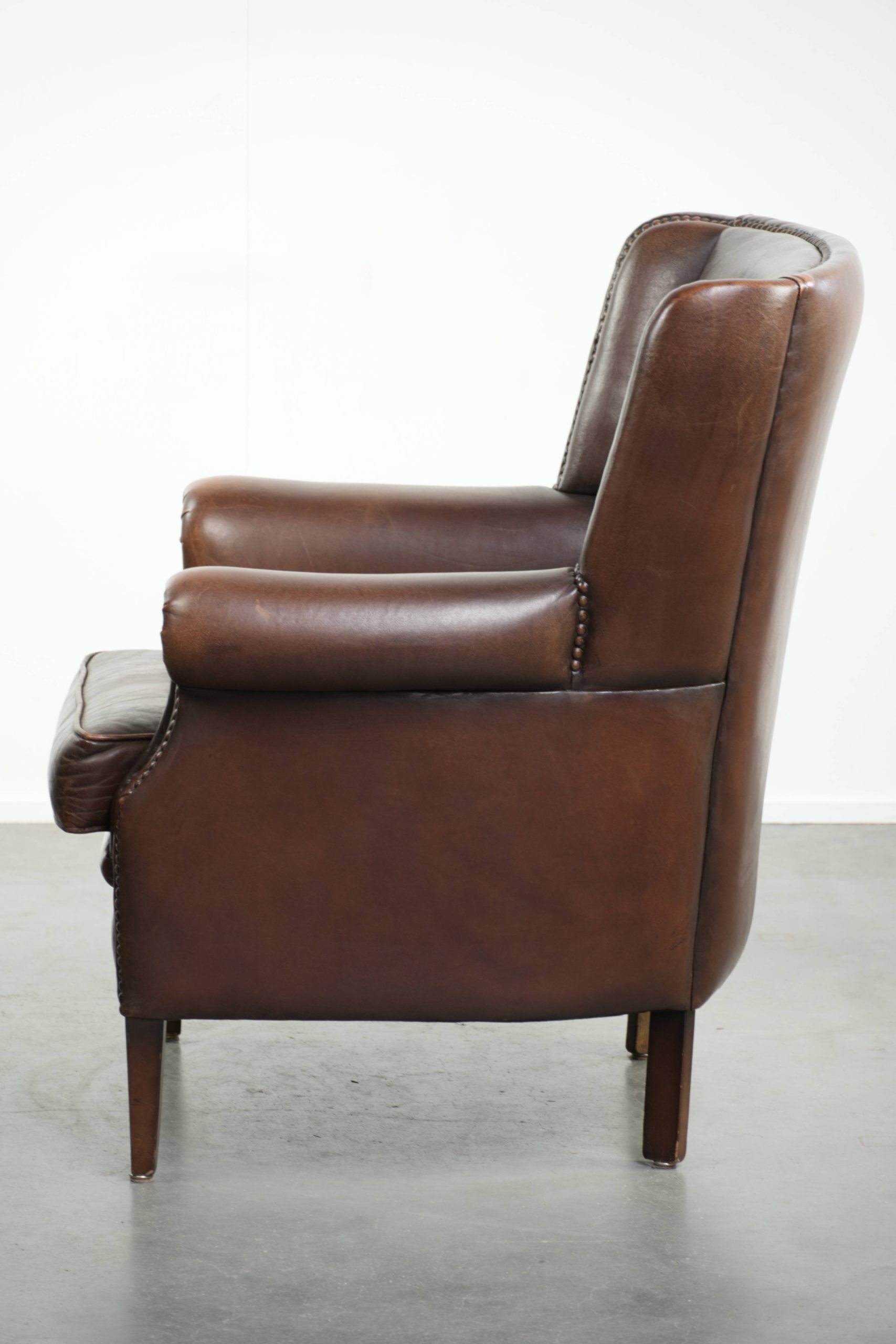 Subtle sheepskin wingback armchair with a deep cognac colour