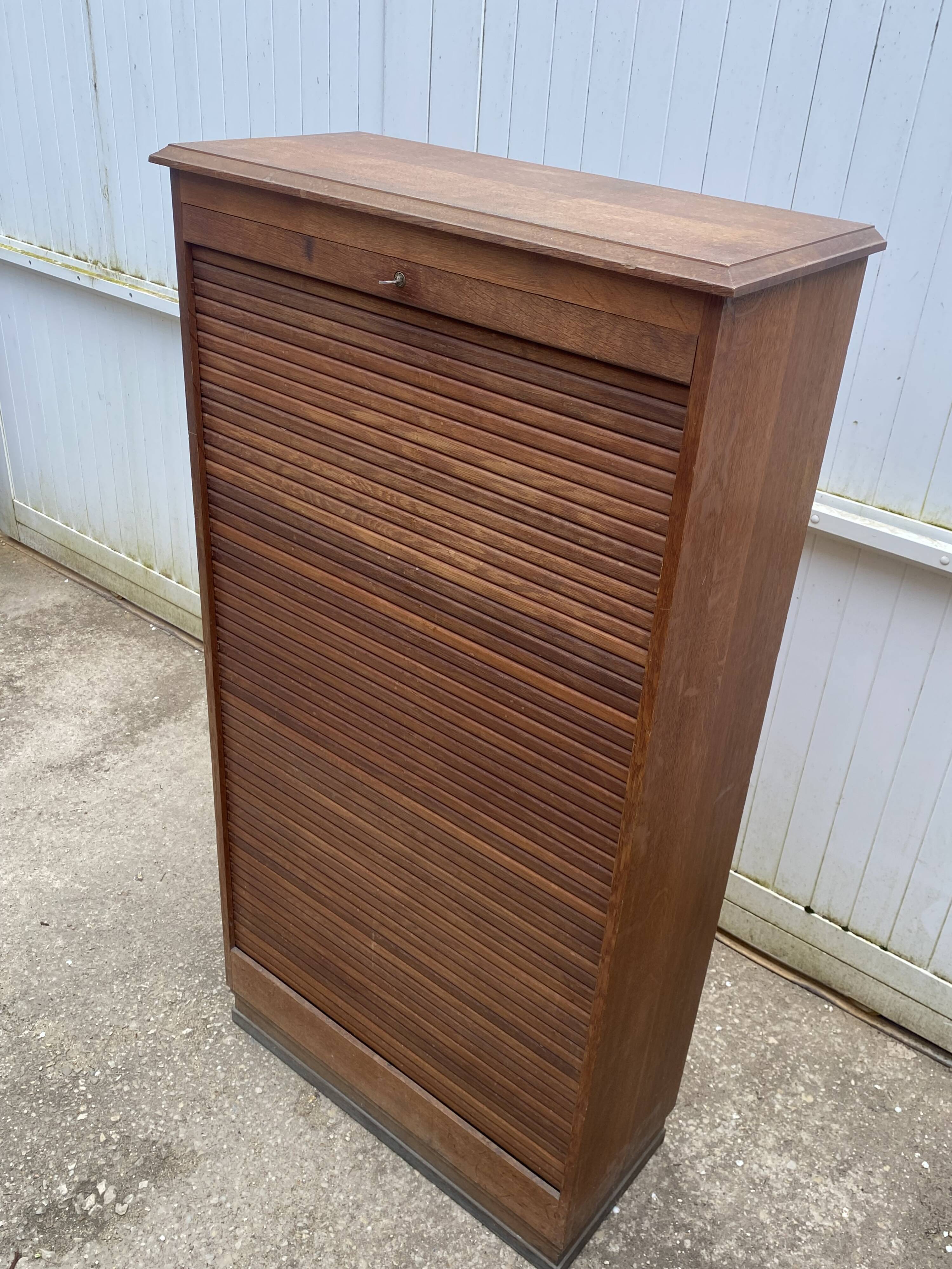 Oak two-column filing cabinet with curtains.