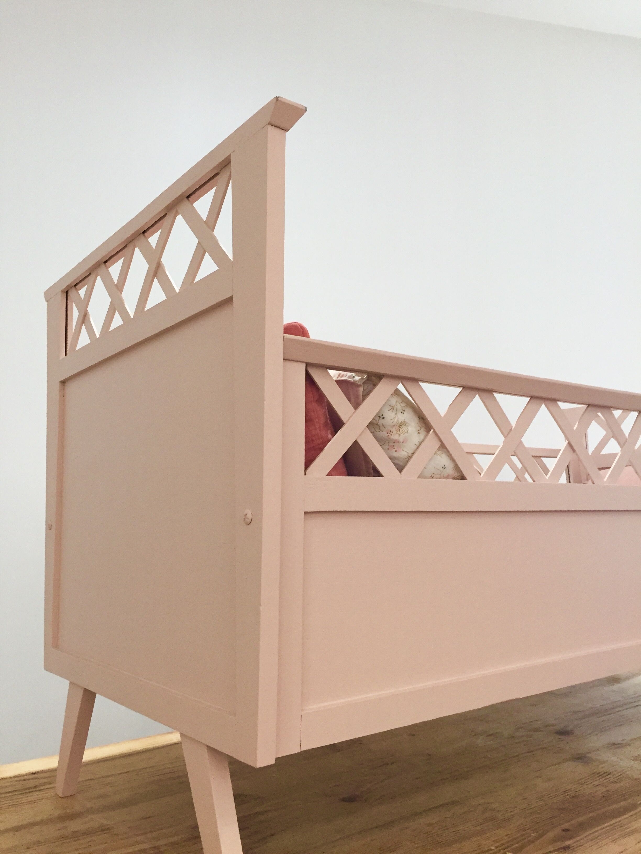 Vintage wooden baby bed in old pink