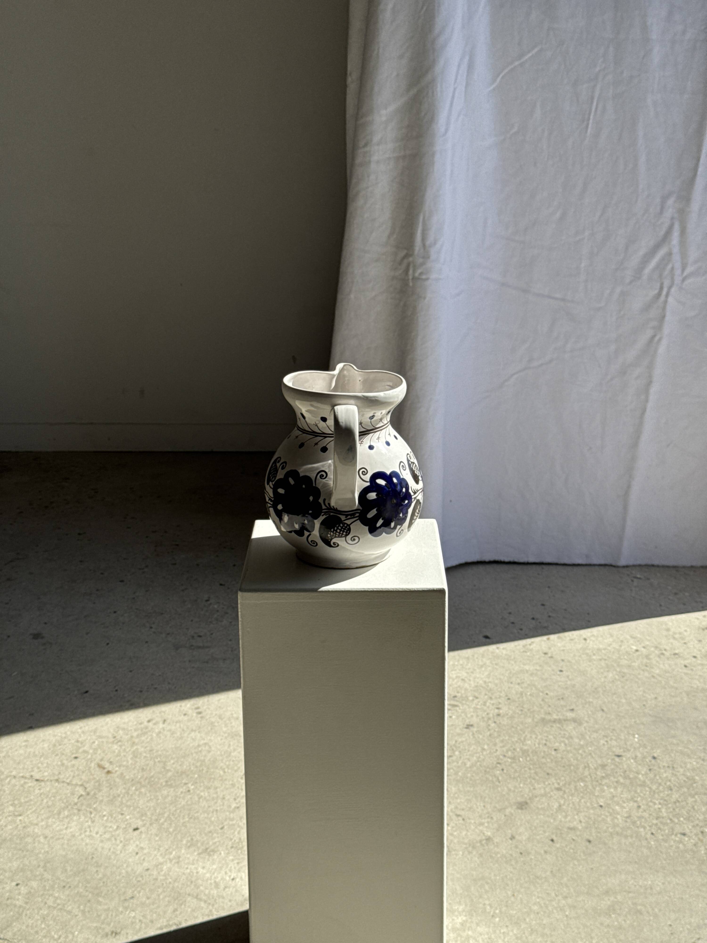 Very large vintage ceramic carafe in white glazed with blue floral decoration.