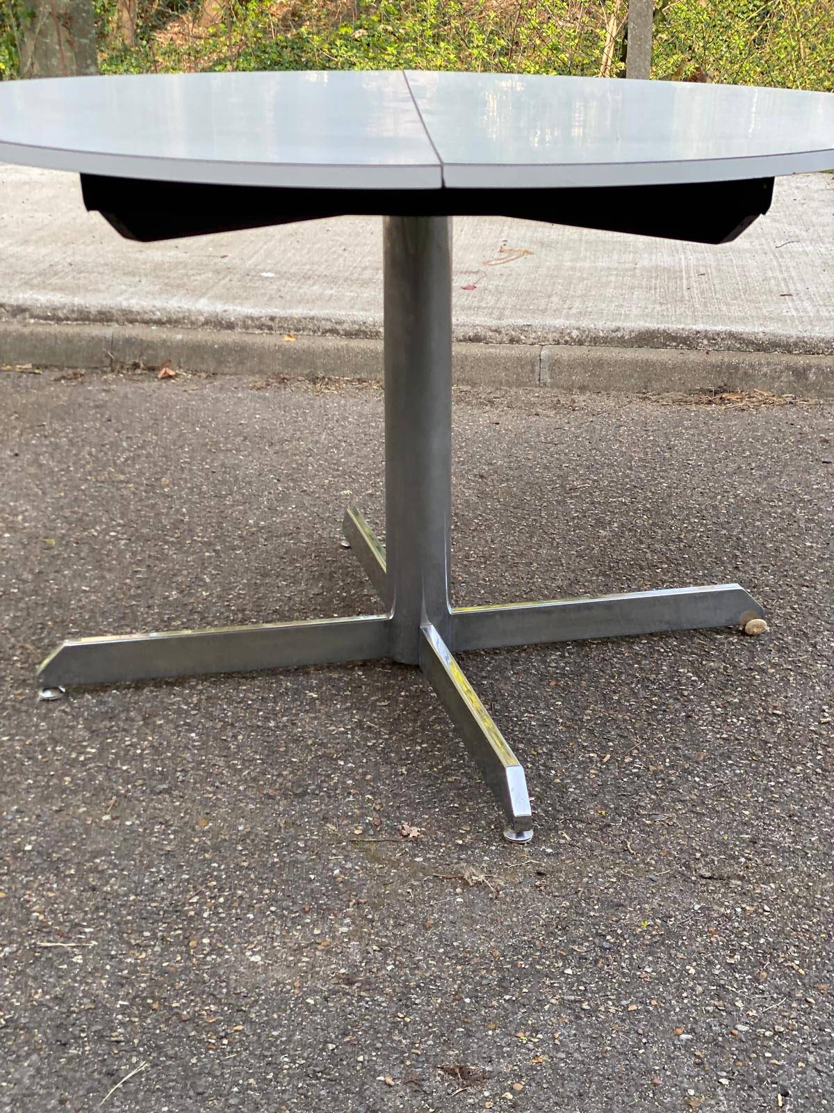 White dining table with a central pedestal, extendable, from the 1970s.