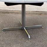 White dining table with a central pedestal, extendable, from the 1970s.