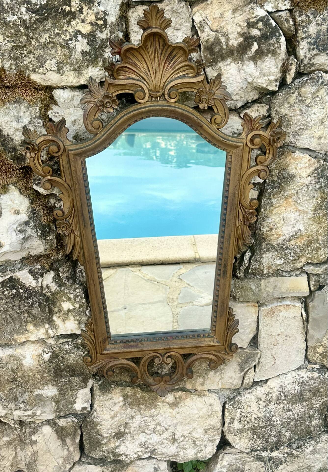 Carved and gilded wooden wall mirror.