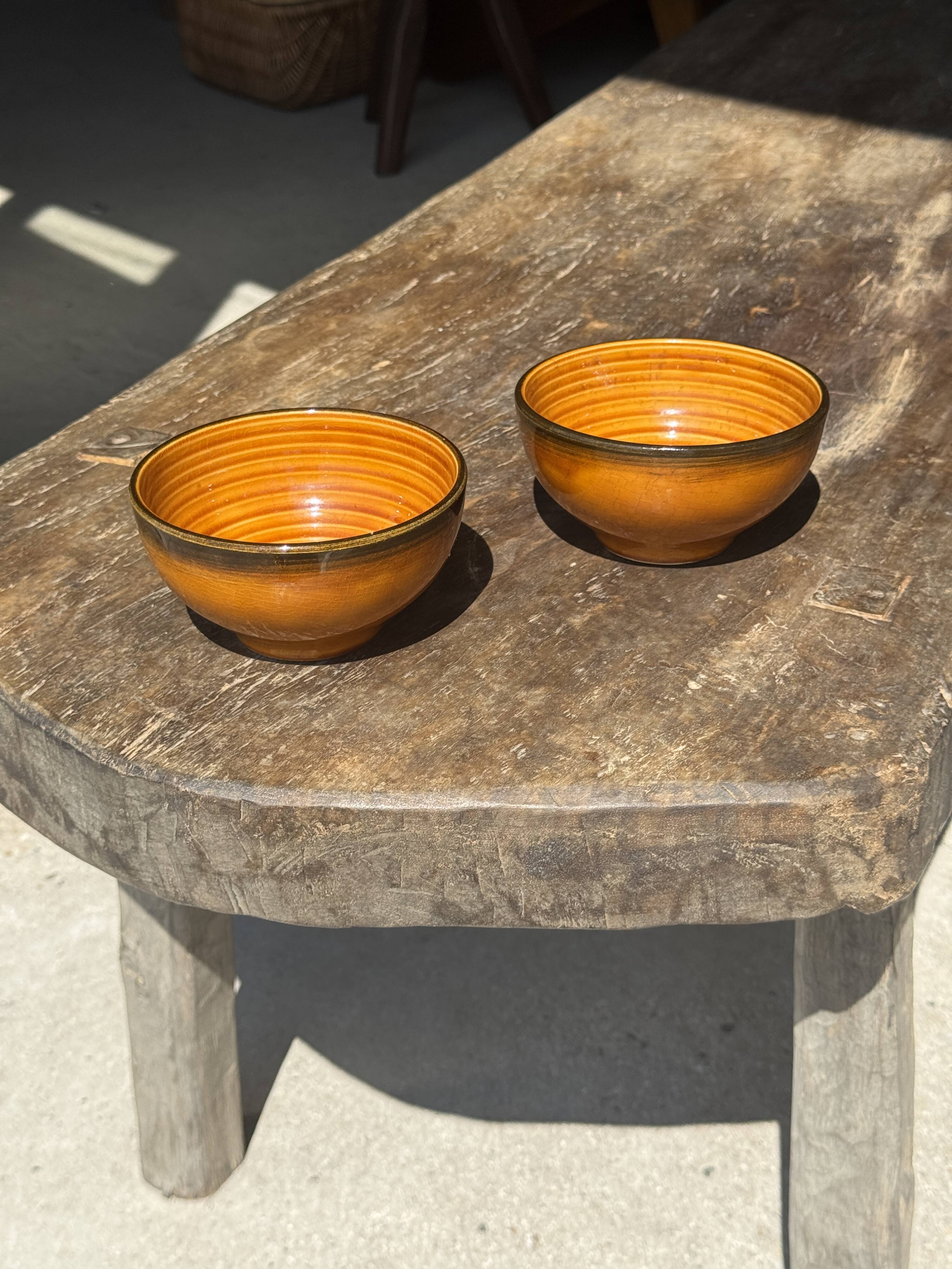 Pair of small orange bowls with black edging