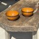 Pair of small orange bowls with black edging