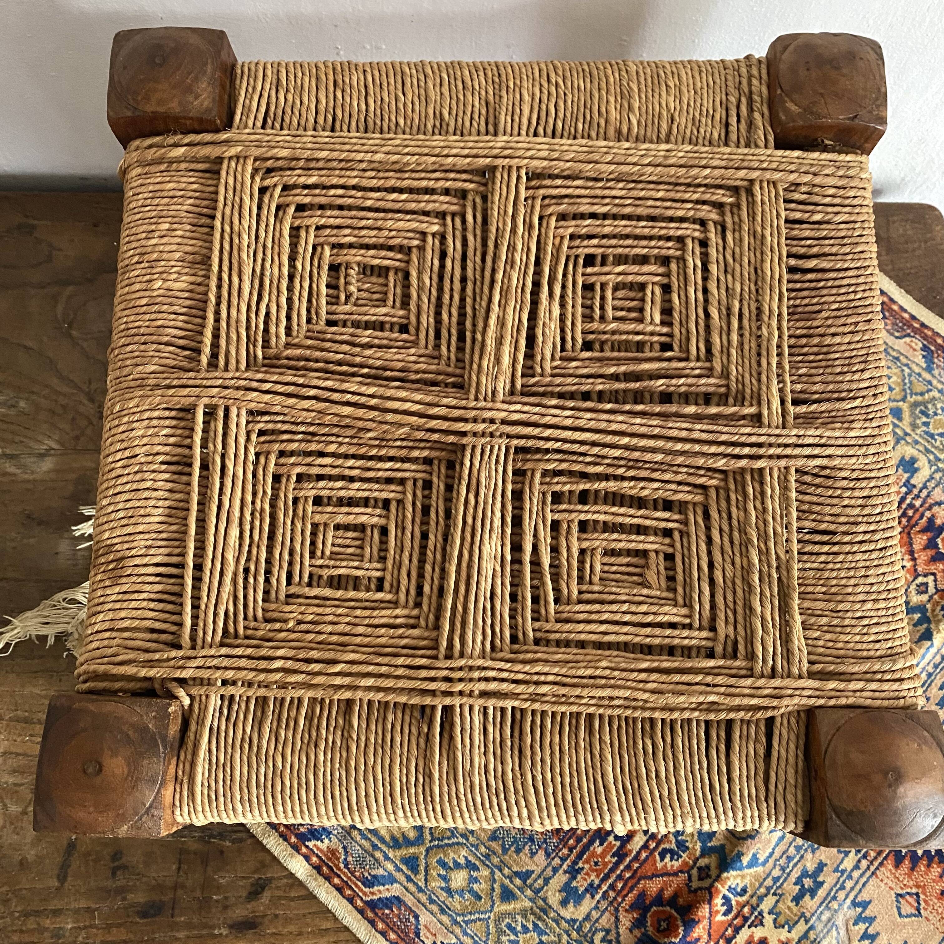 Low stool with carved wood and braided cord.