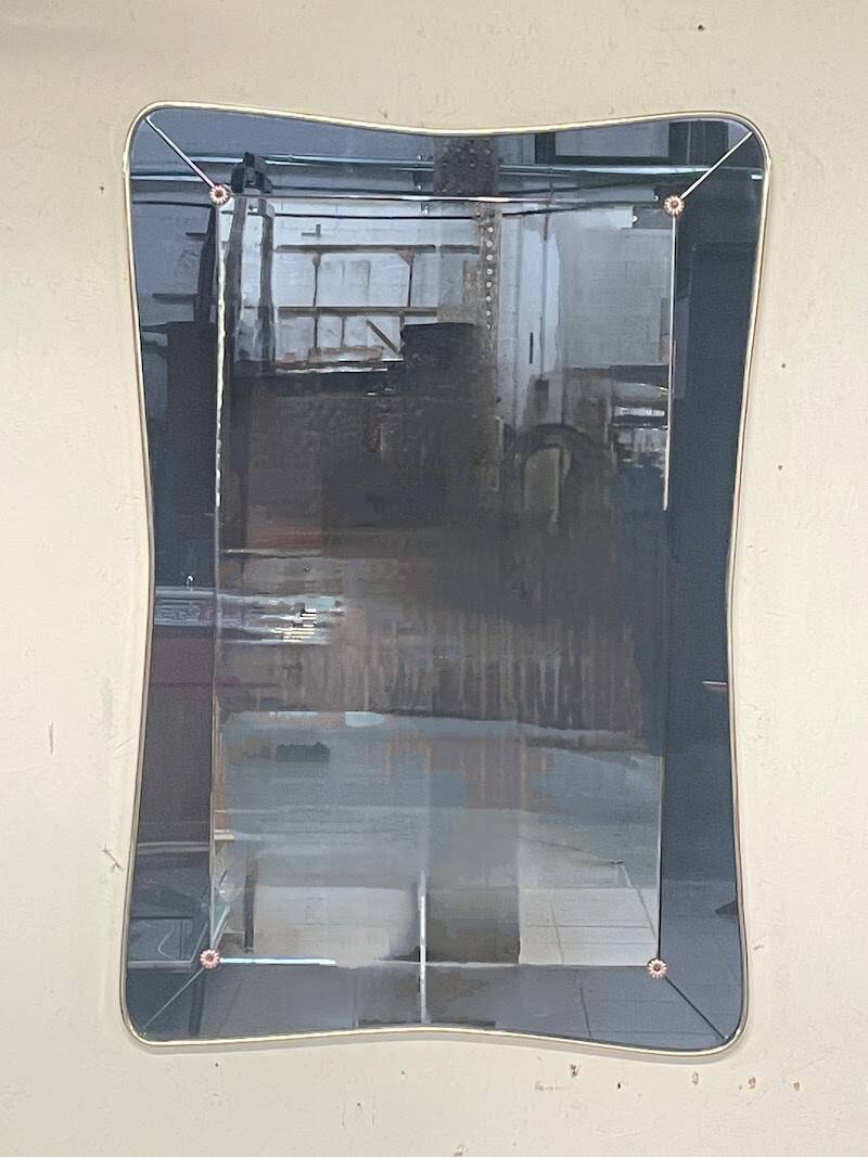 1950s double-thickness wall mirror with brass profile and supports.