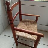 Children's wooden armchair and straw-covered seat.