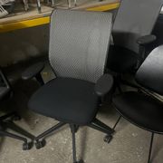 Vitra ID Trim office chair by Antonio Citterio — black mesh backrest and blue fabric seat, aluminium frame.