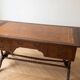 Antique wooden desk with a faux leather top and extensions.