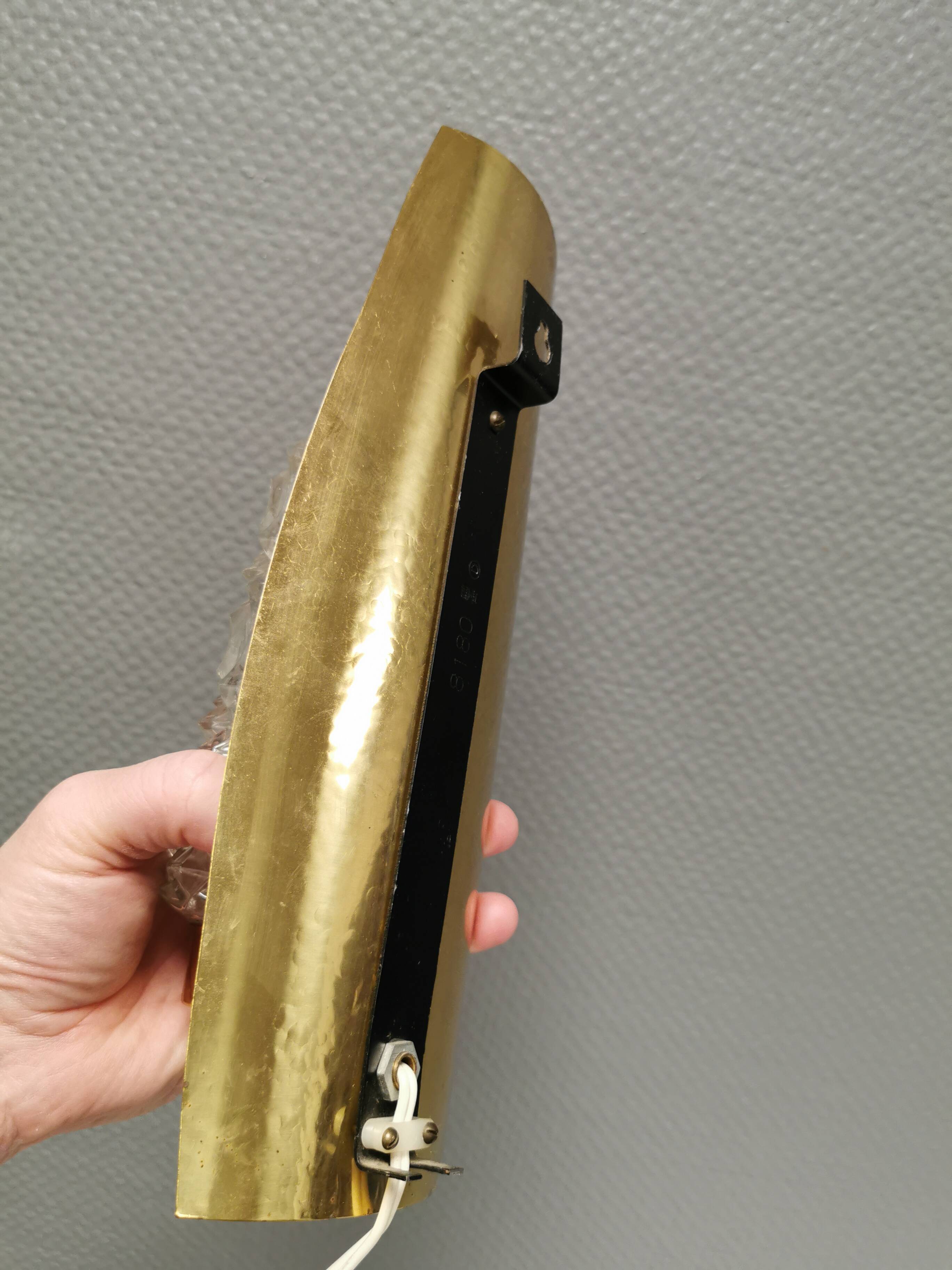 Older wall lamp in brass with hard pressed glass shade.