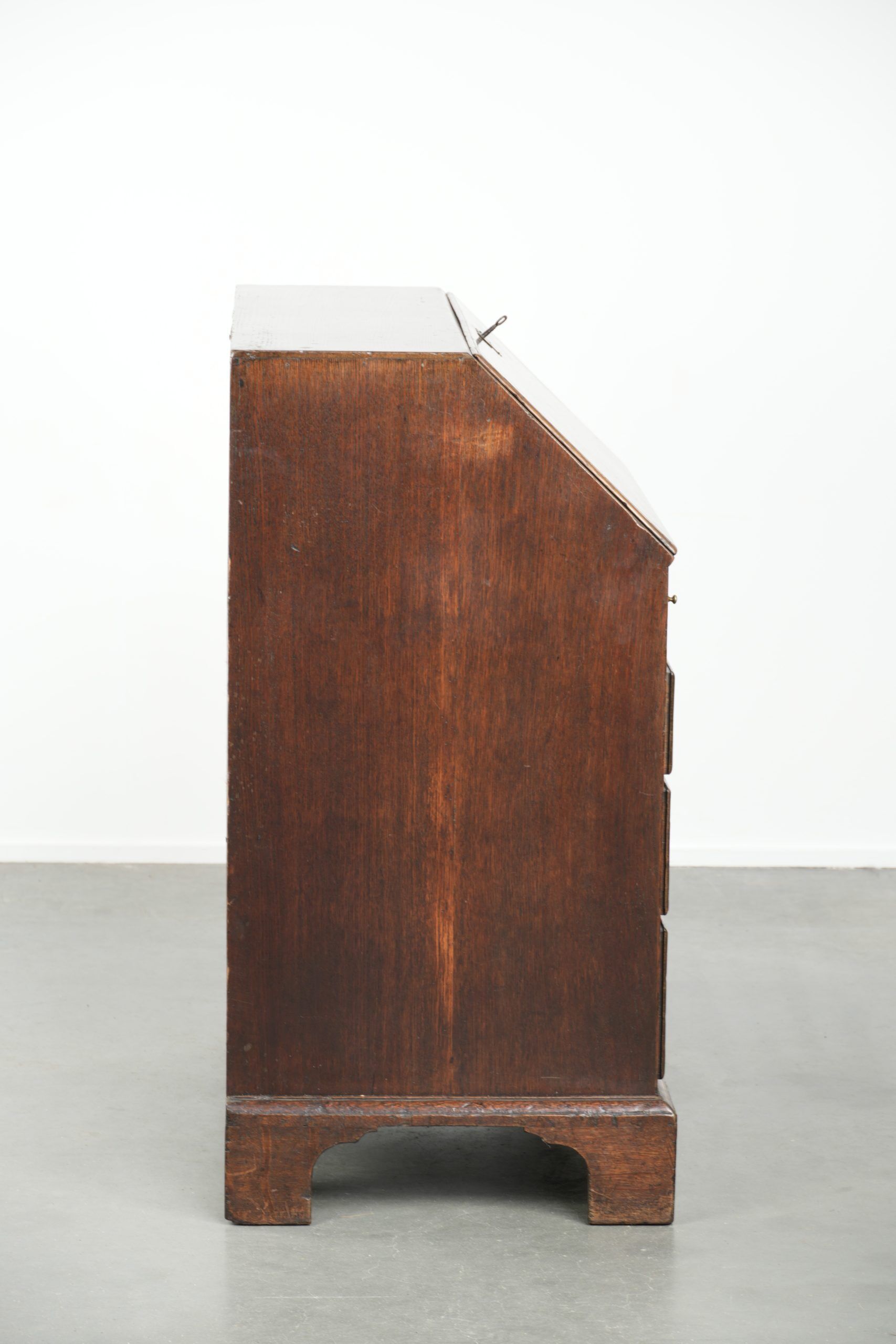 Antique English oak secretary from the 18th century with a stepped interior