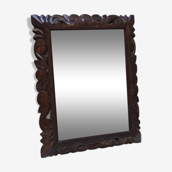 Old beveled mirror with carved wooden frame