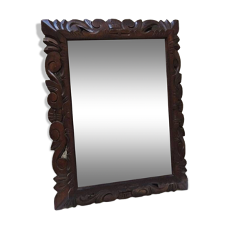 Old beveled mirror with carved wooden frame