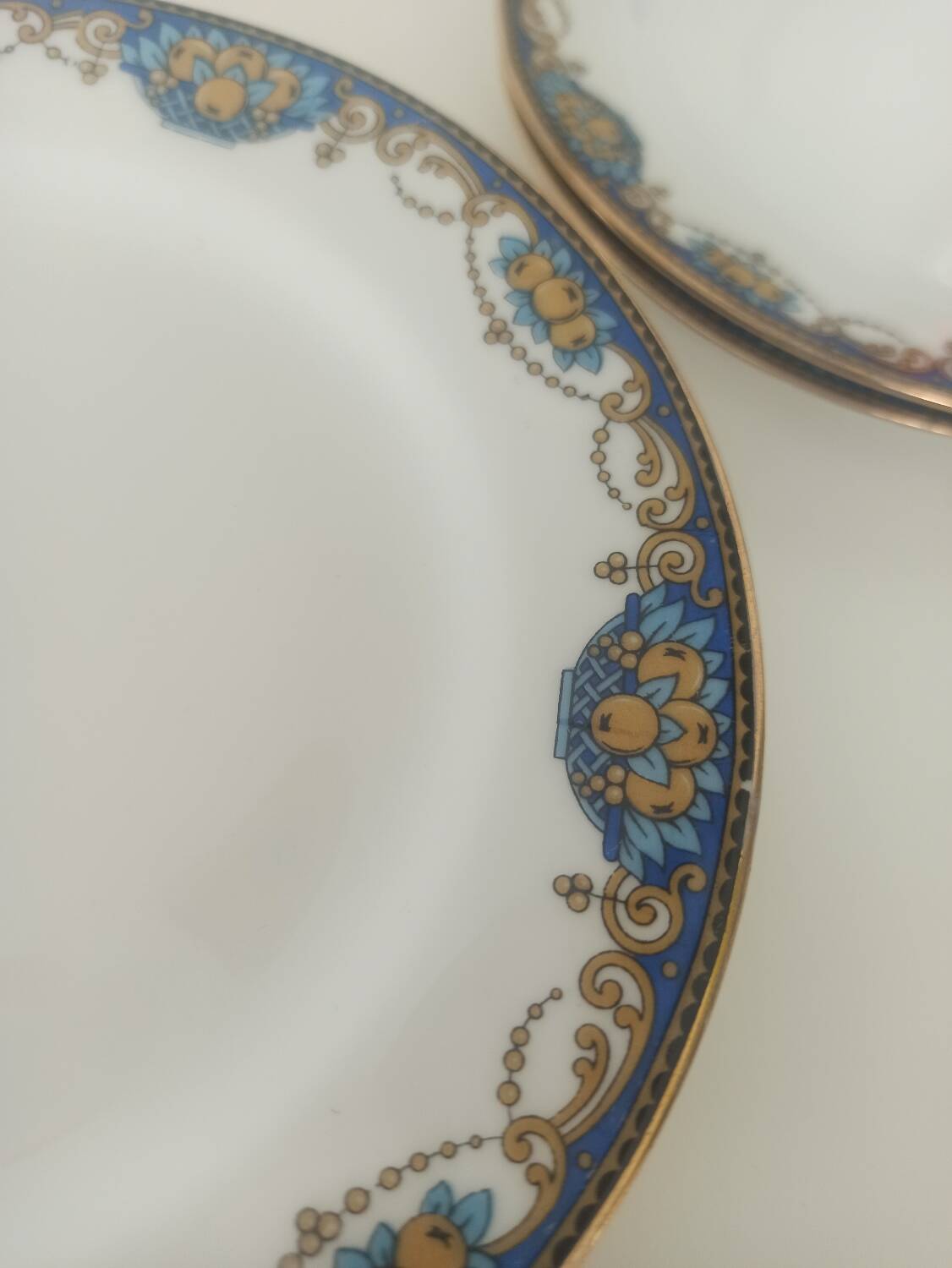 12 assiettes en porcelaine de Limoges à décor de guirlandes et de fruits