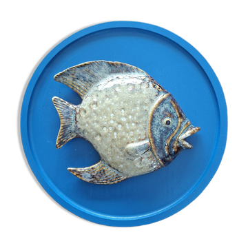 Vallauris ceramic wall sculpture of a relief fish on a blue plaque.