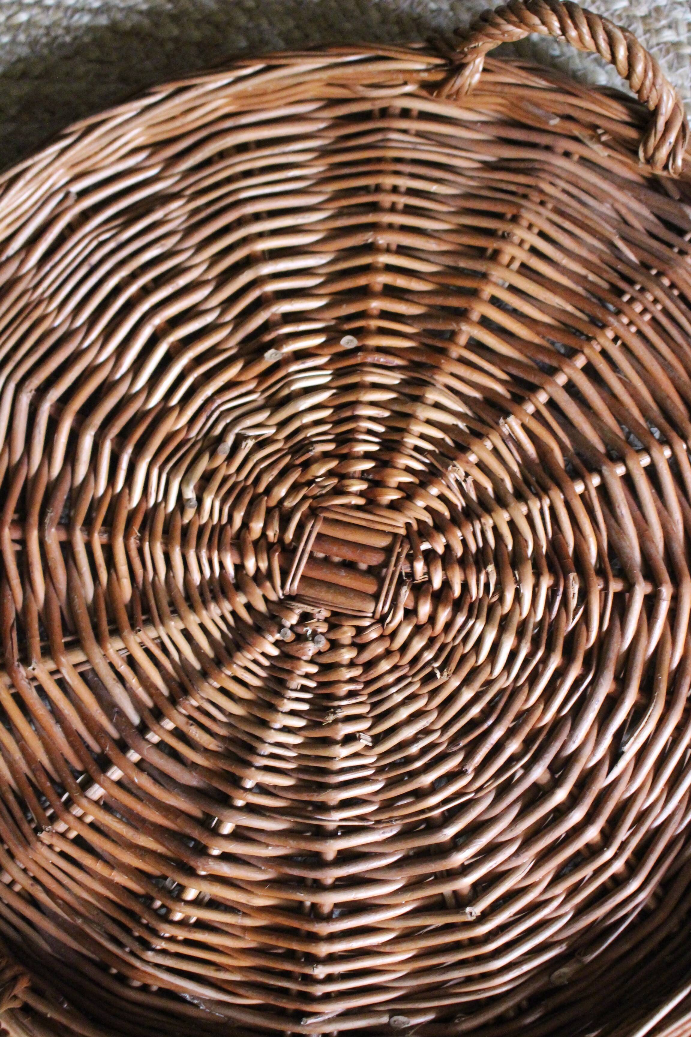 Large round dark wicker tray with two handles.