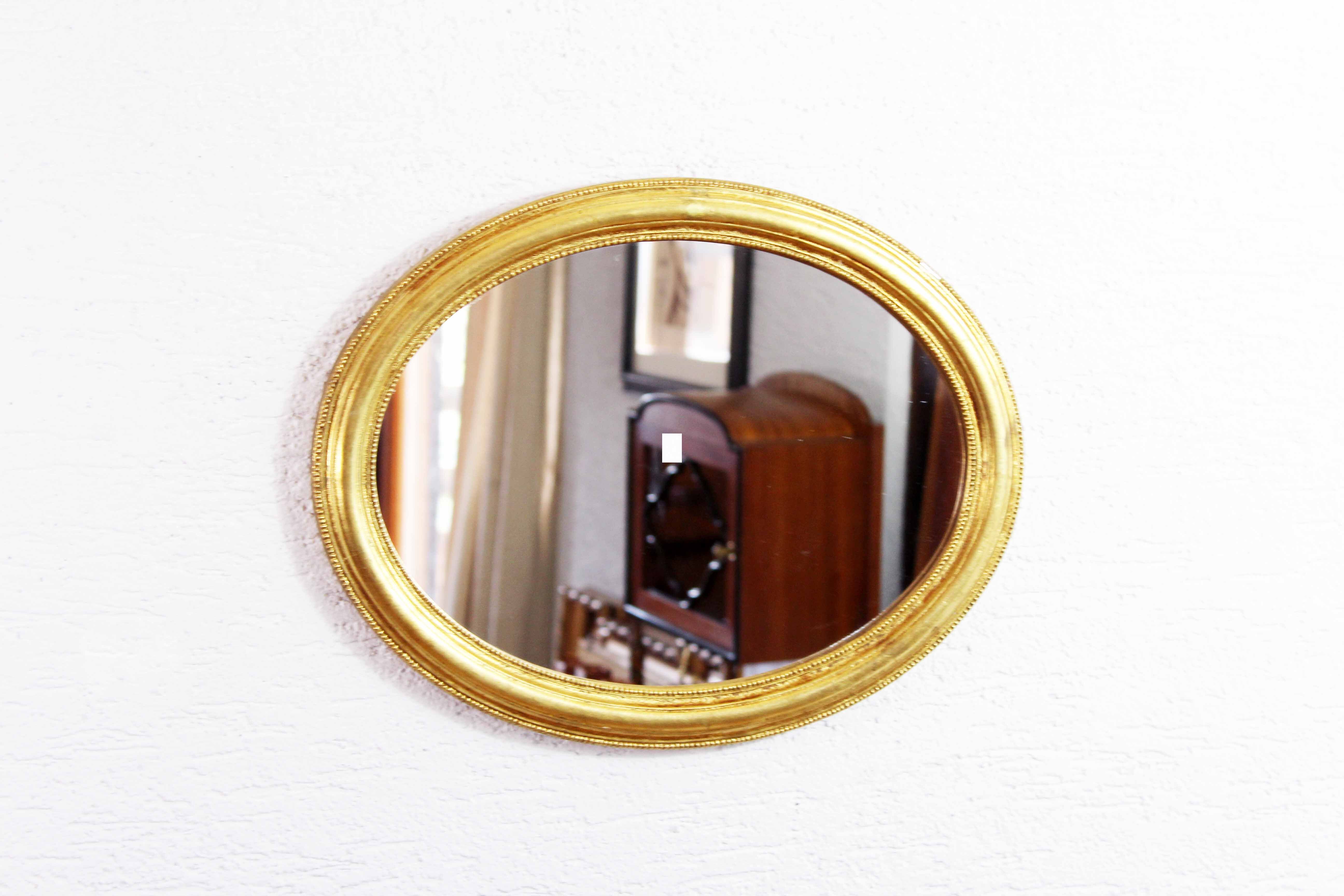 Golden oval mirror with leaf