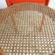 Chaise vintage en bois laqué orange et assise cannage