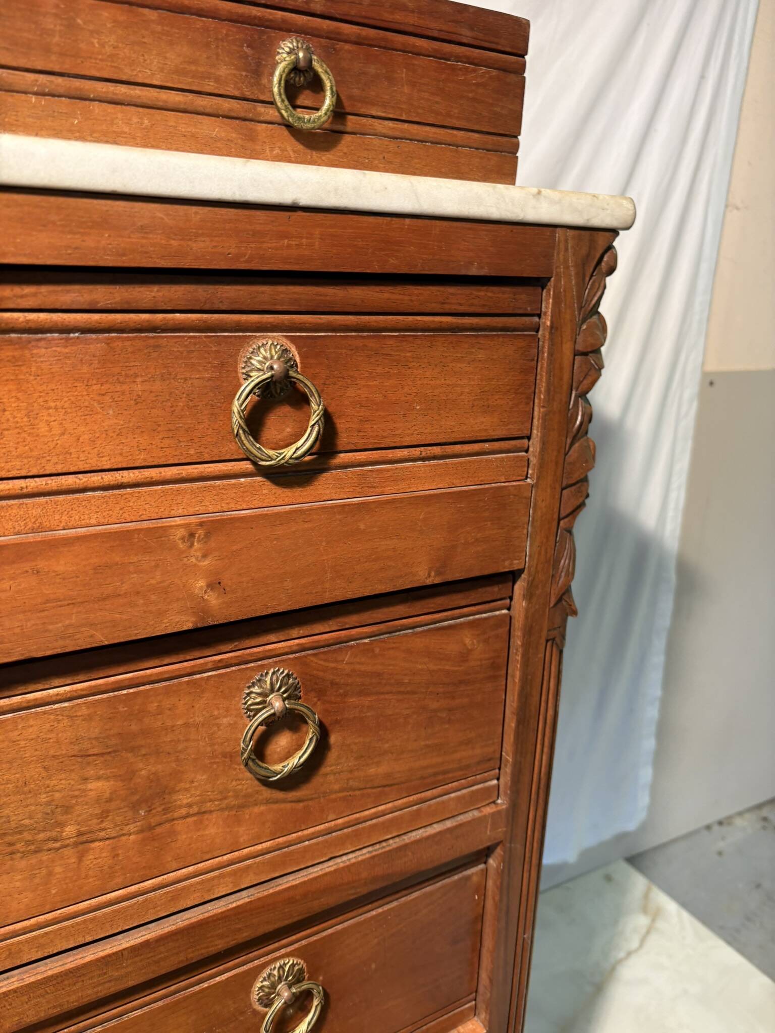 Antique carved wooden dressing table with marble and tilting oval mirror.