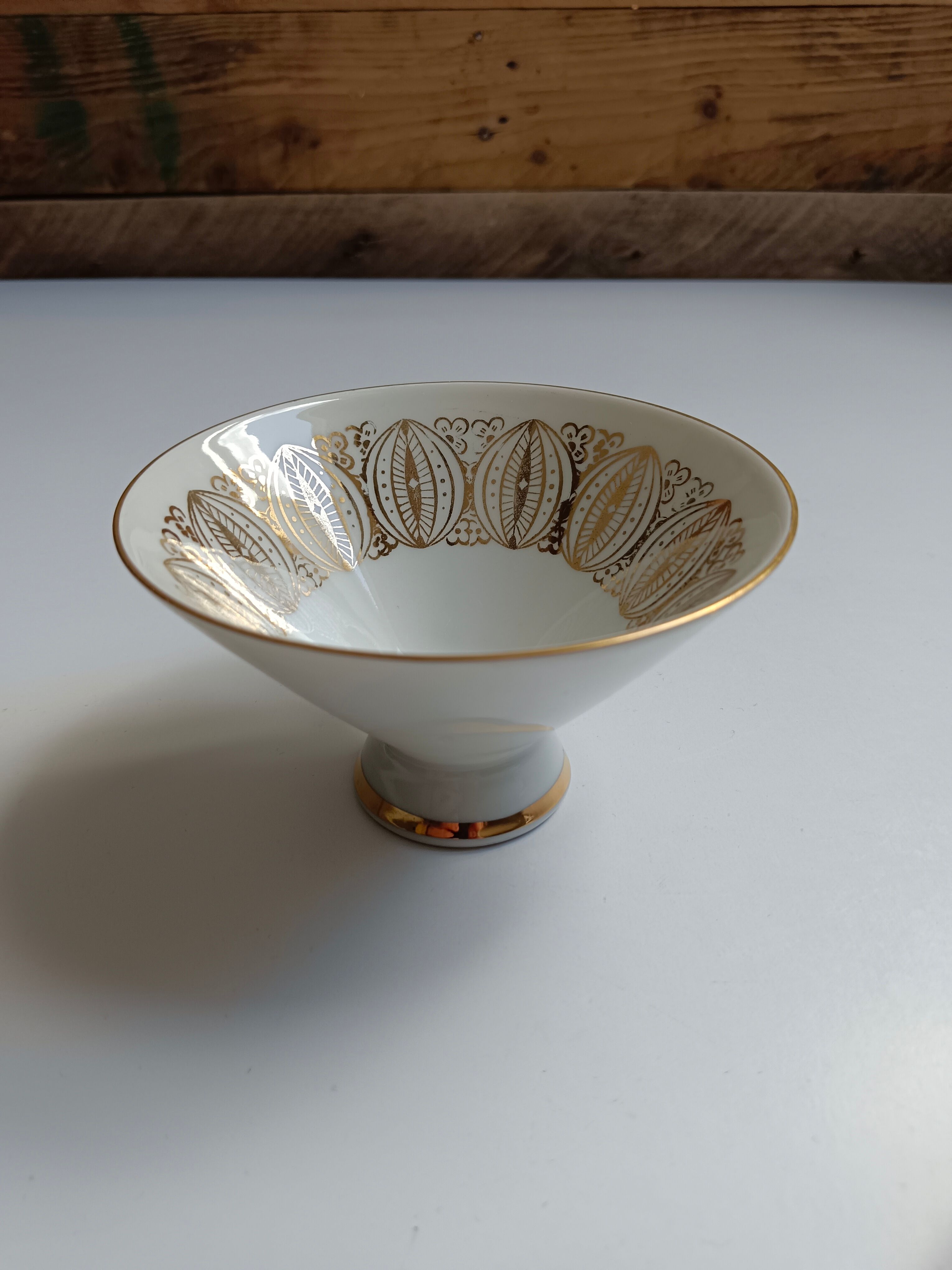 Solitaire tea cup, saucer, and dessert plate in white and gold.