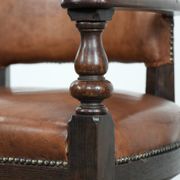 Elegant antique sheepskin leather desk chair with a heavy wooden frame