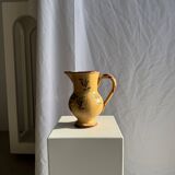 Large antique handmade ochre yellow jug with a pink flower pattern.