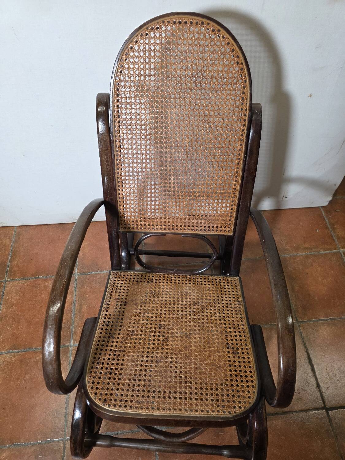 Curved wooden rocking chair with caning