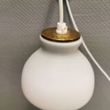 Milky white Holmegaard wall lamp with glass shade and a brass detail on top. Wooden wall bracket