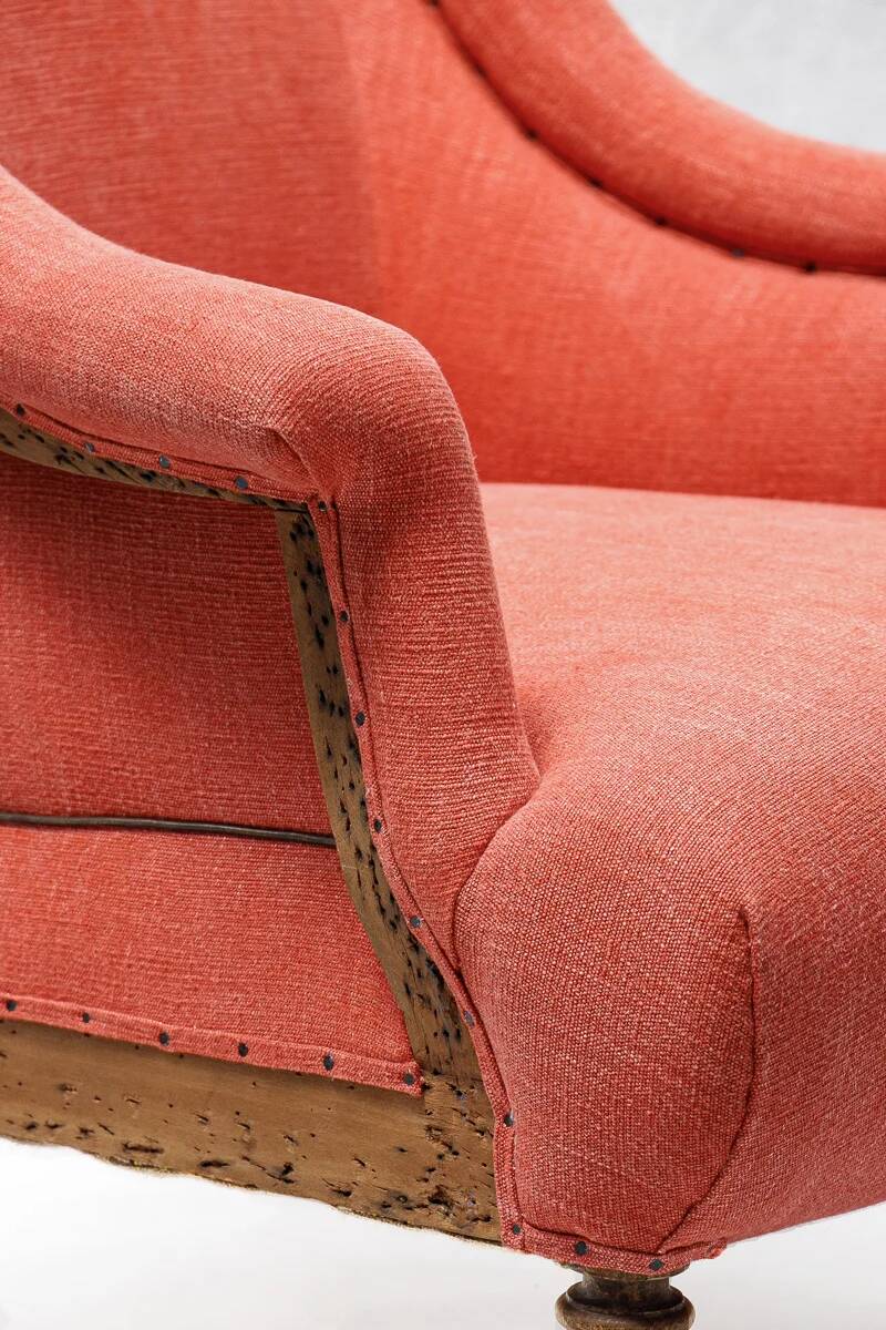 Napoleon III salon armchair in brick red linen with a tufted footrest.