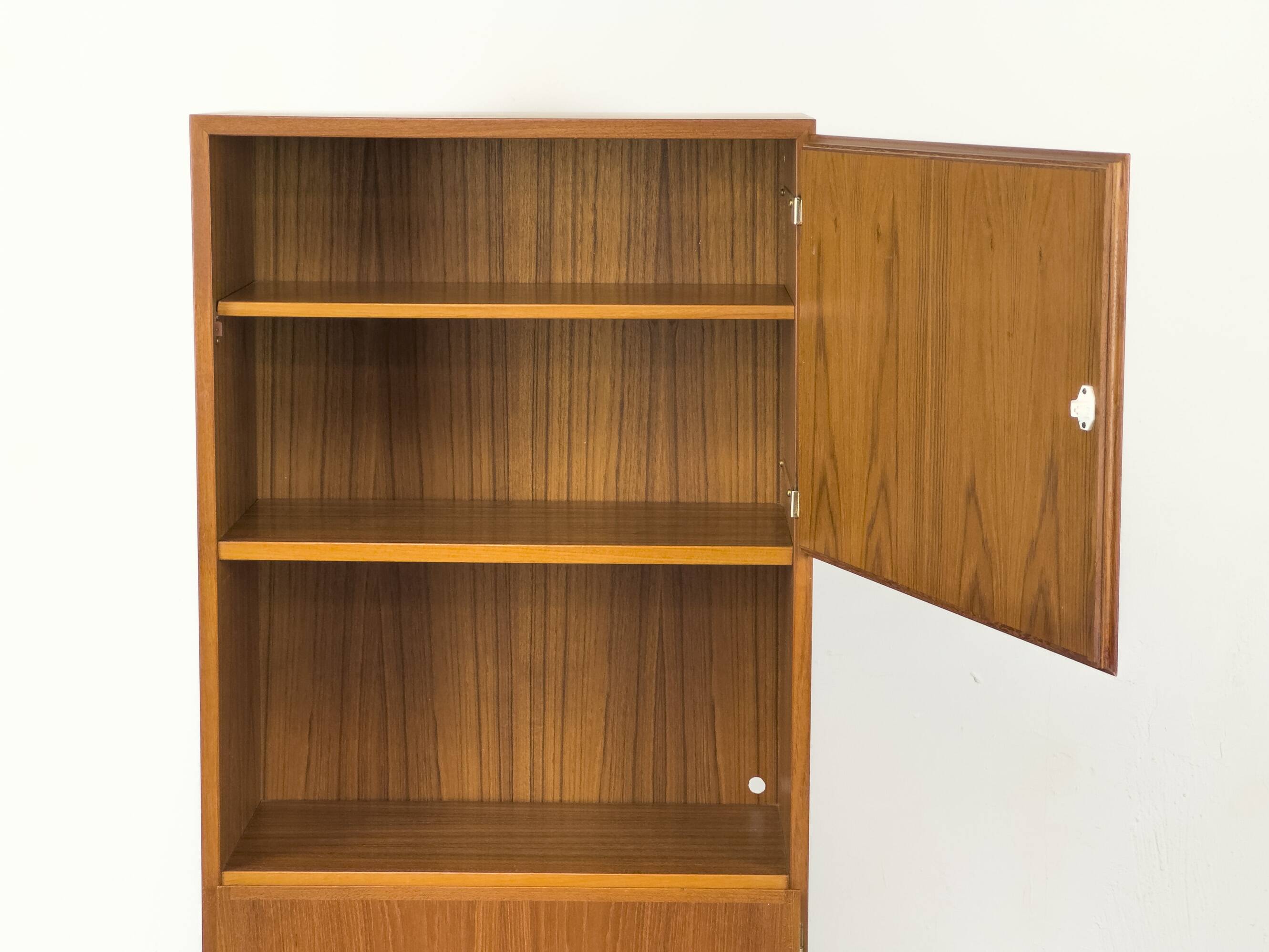 Narrow teak bookcase with two doors by Omann Jun, 1970s