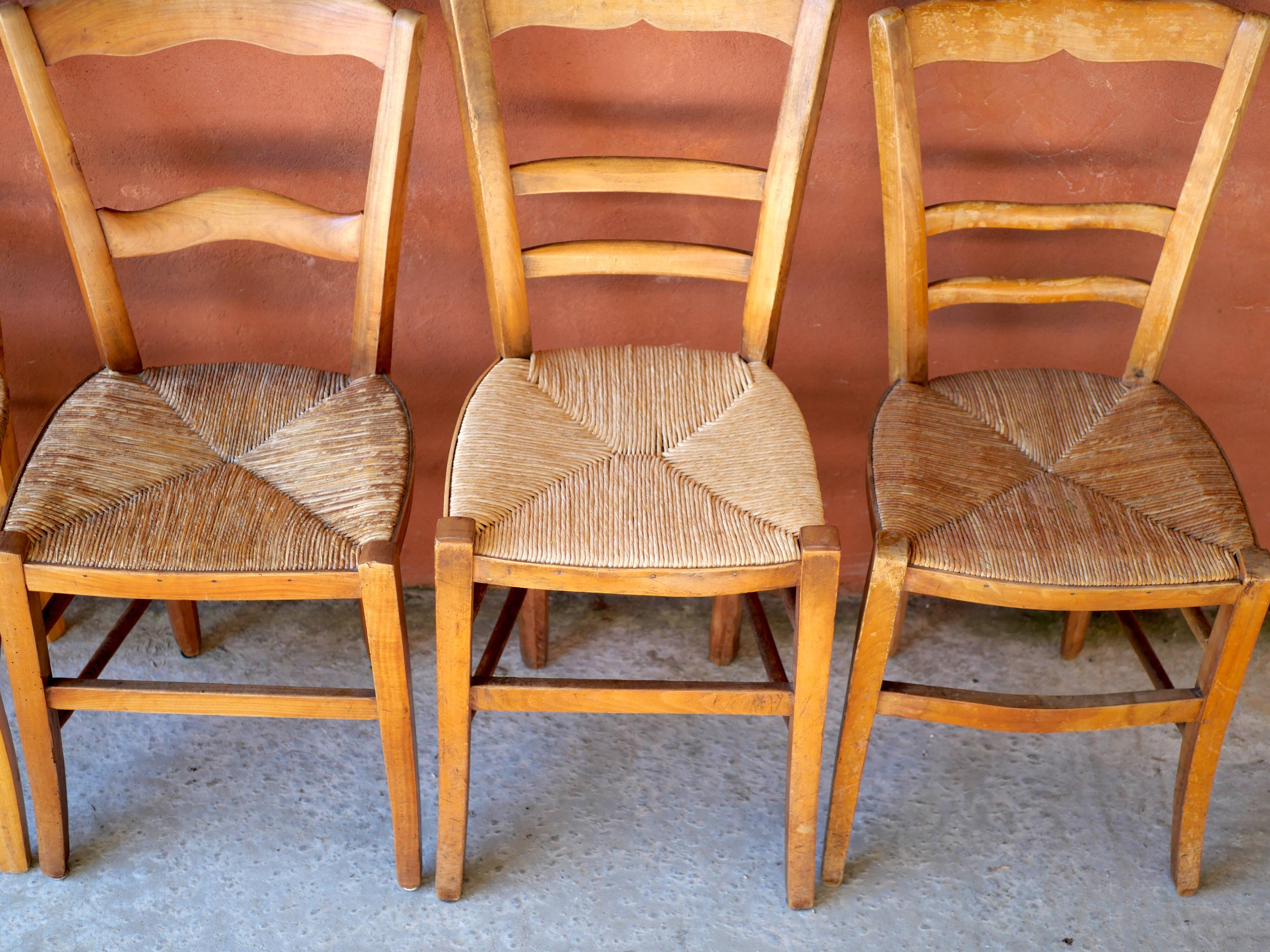 Set of 5 mismatched straw chairs.