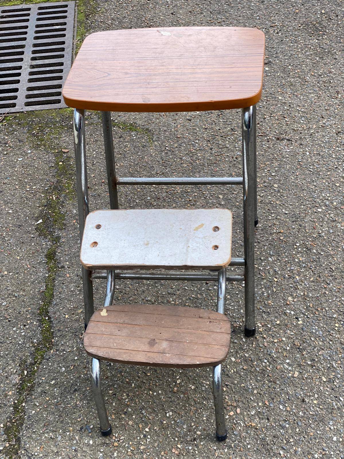 Folding stool in formica with a wood effect.