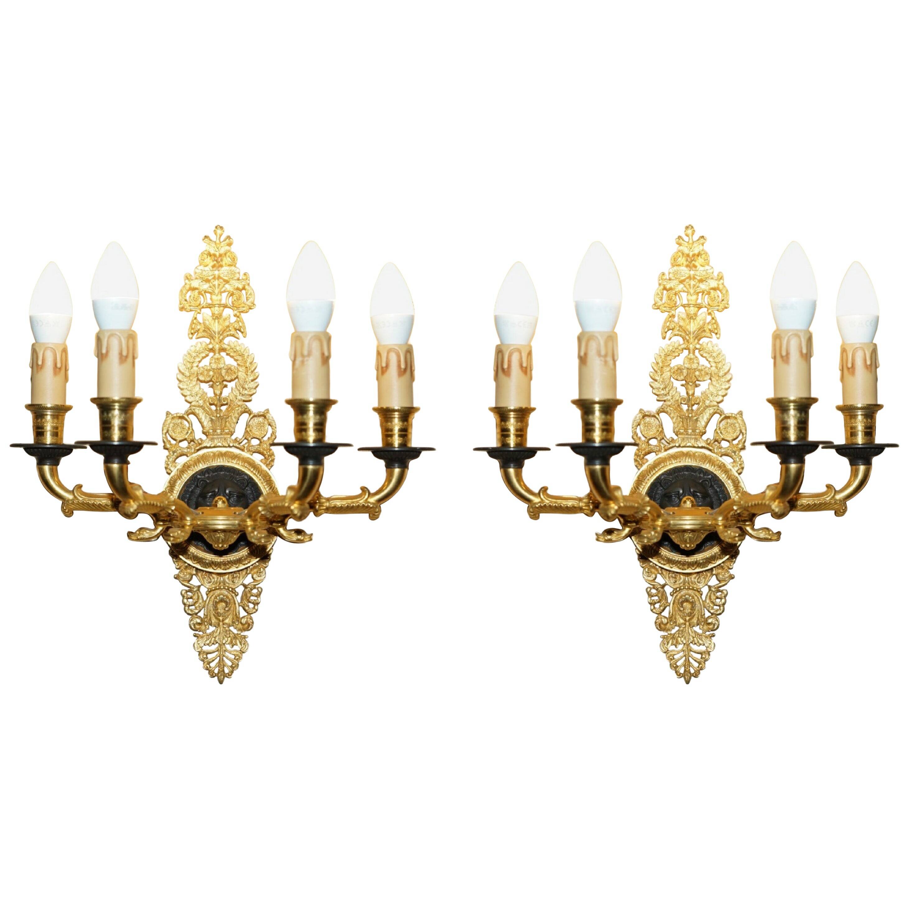Pair of L'Originale wall sconces plated with 24-carat gold featuring four bronze candles.