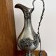 Ewer in pewter surrounded by vine branches with g