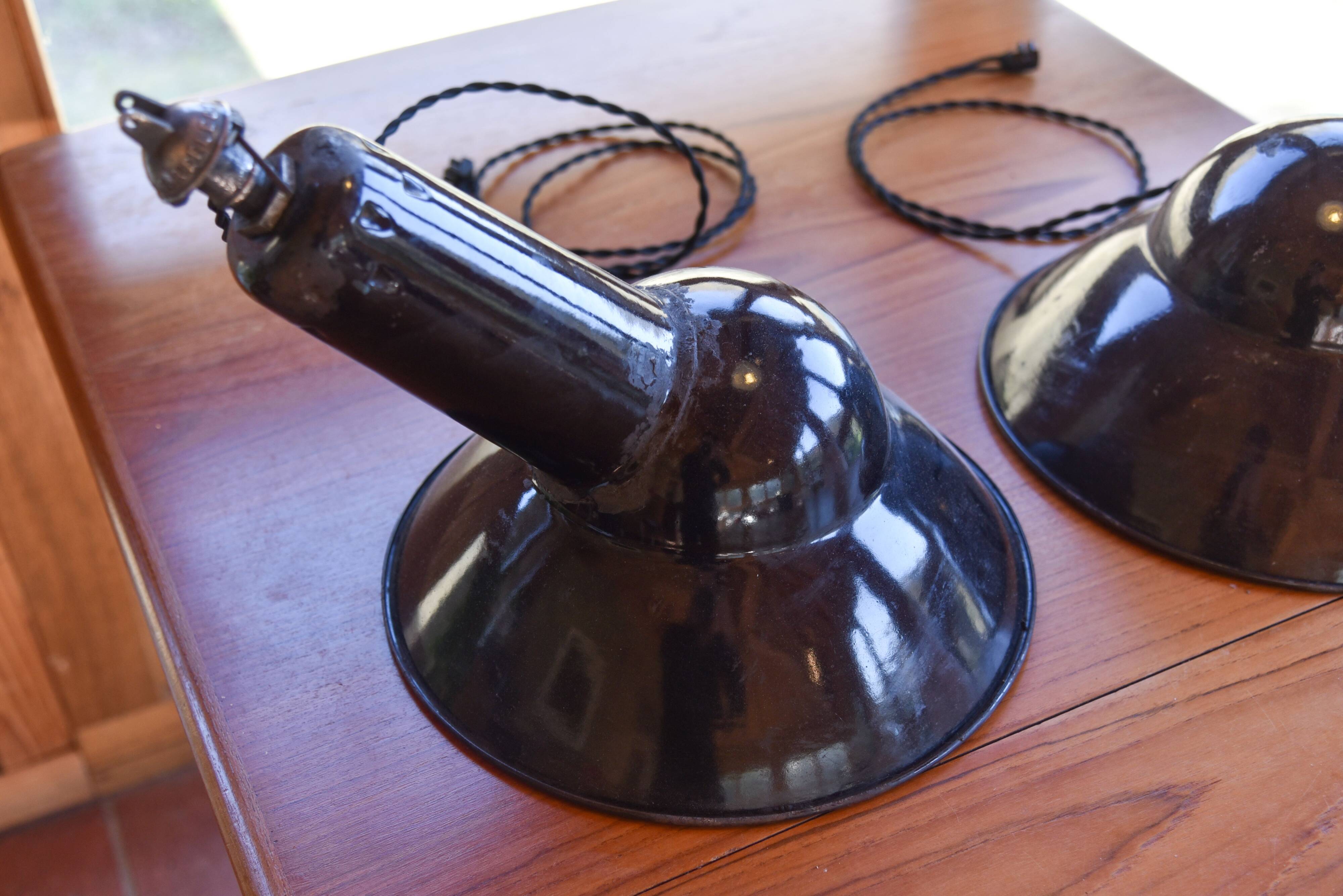Pair of black enamelled sheet metal pendant lights from the 1950s.